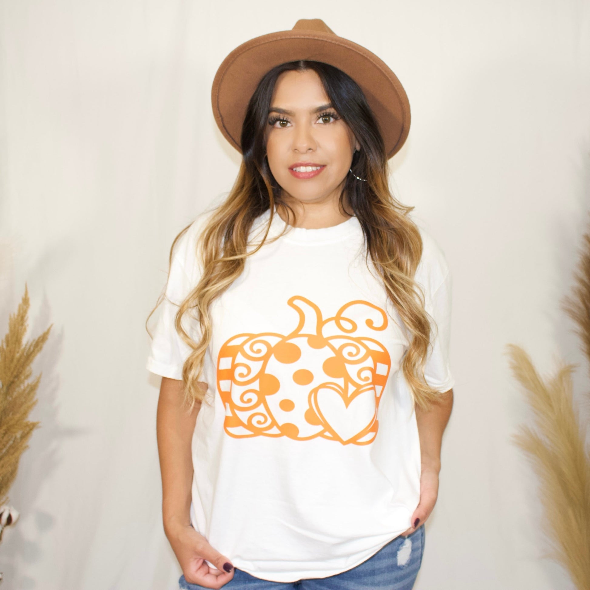 front side, close up white t-shirt with a pumpkin and with a heart print in color orange