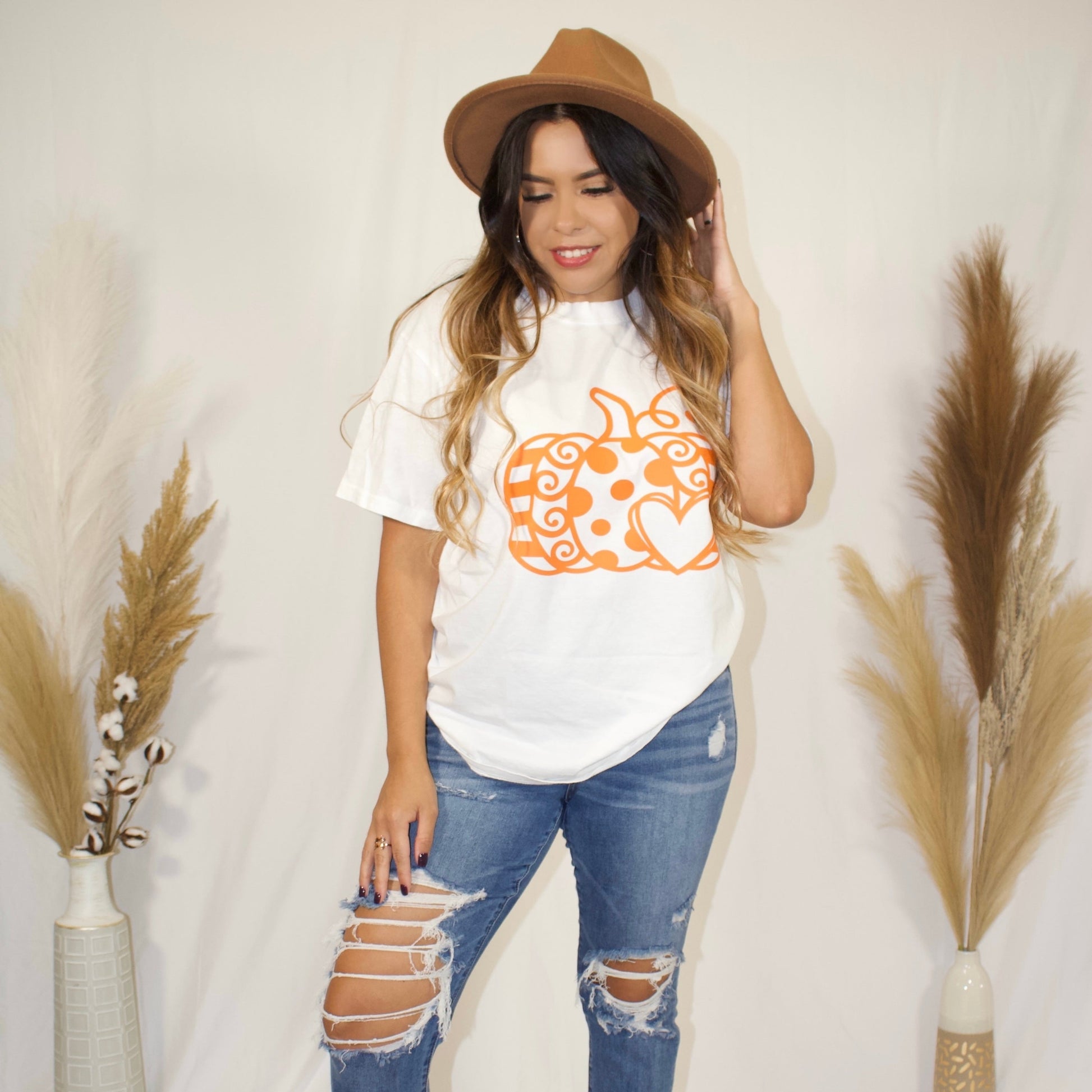 front side, white t-shirt with a pumpkin and with a heart print in color orange