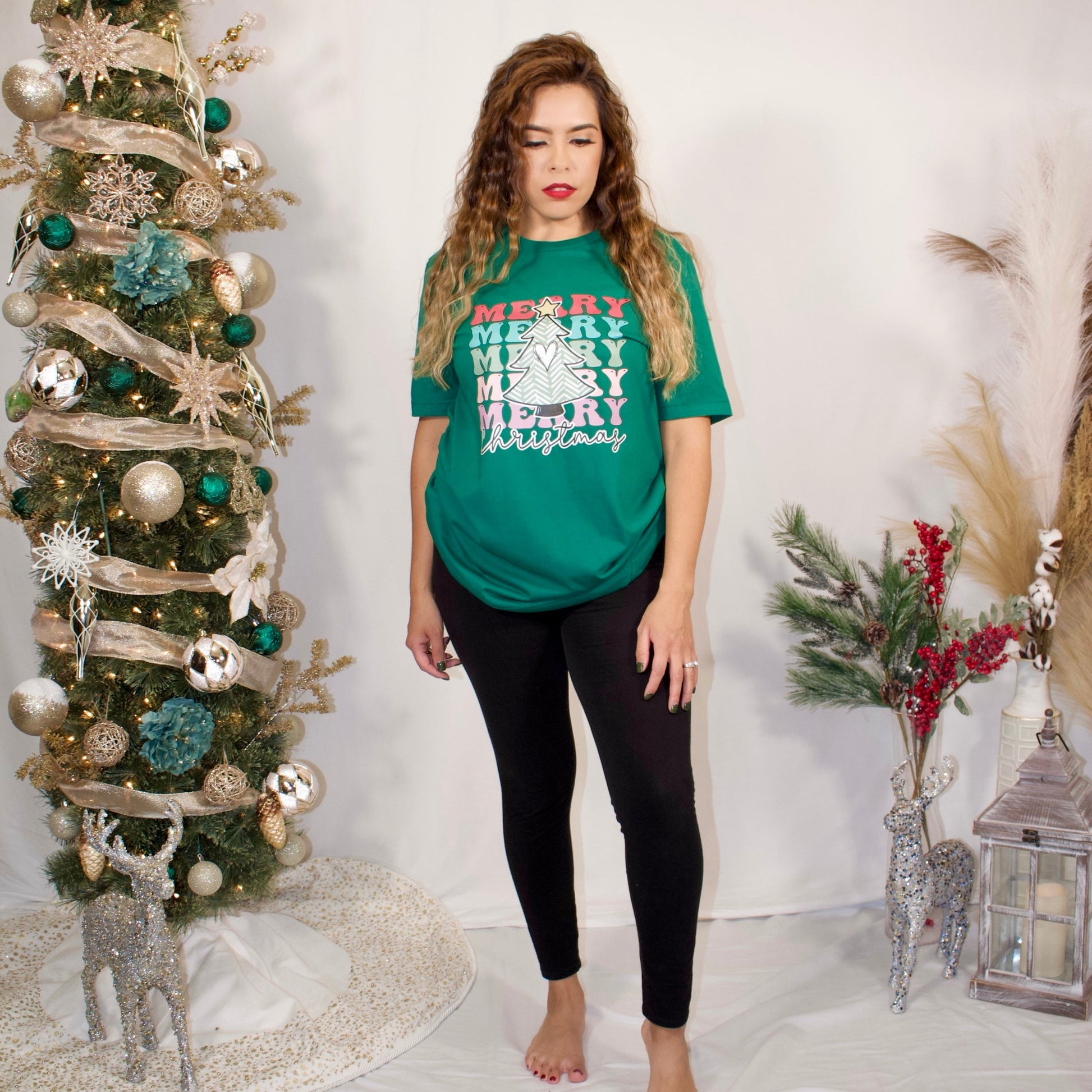 GREEN TSHIRT FRONT SIDE WITH MERRY 3 TIMES AND COLORFUL LETTER AND WITH CHRISTMAS AT THE BOTTOM AND A CHRISTMAS TREE IN THE MIDDLE