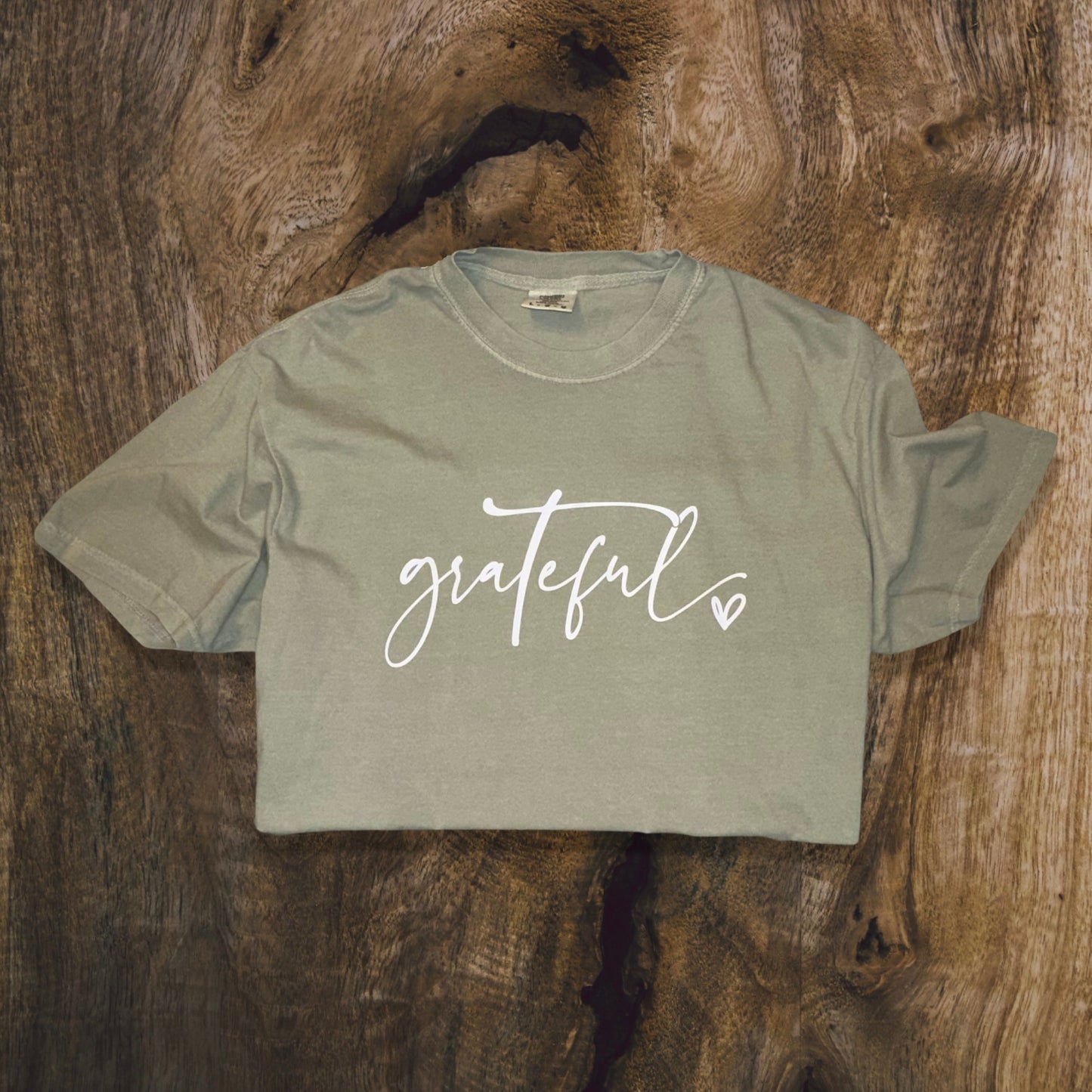 front side, close up of sandstone green t-shirt with wording grateful