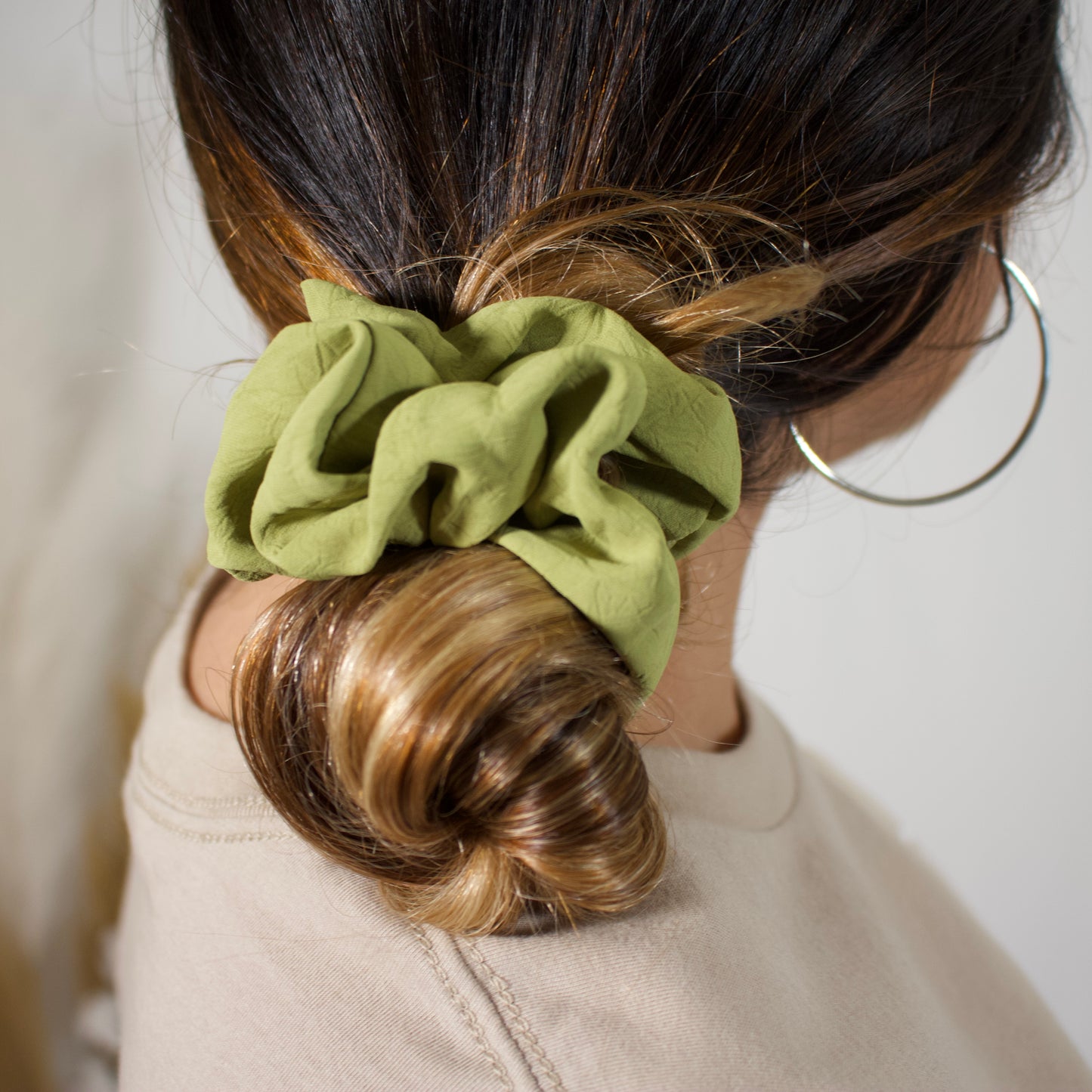 close up of hair bun with a green scrunchie 