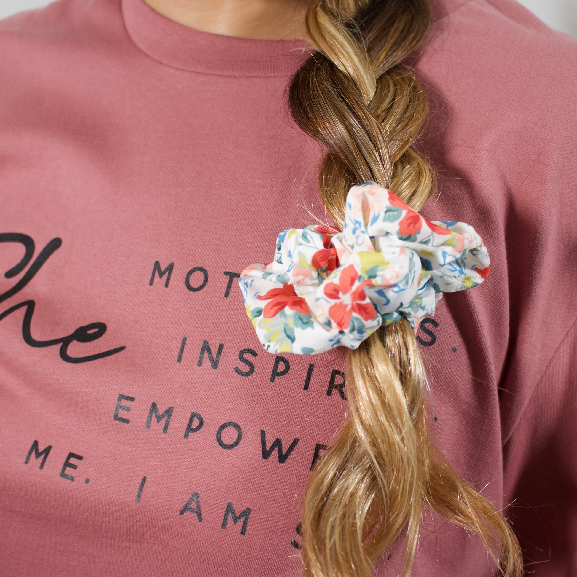 wearing a hair braid with a orange, blue, green, light pink scrunchie close up