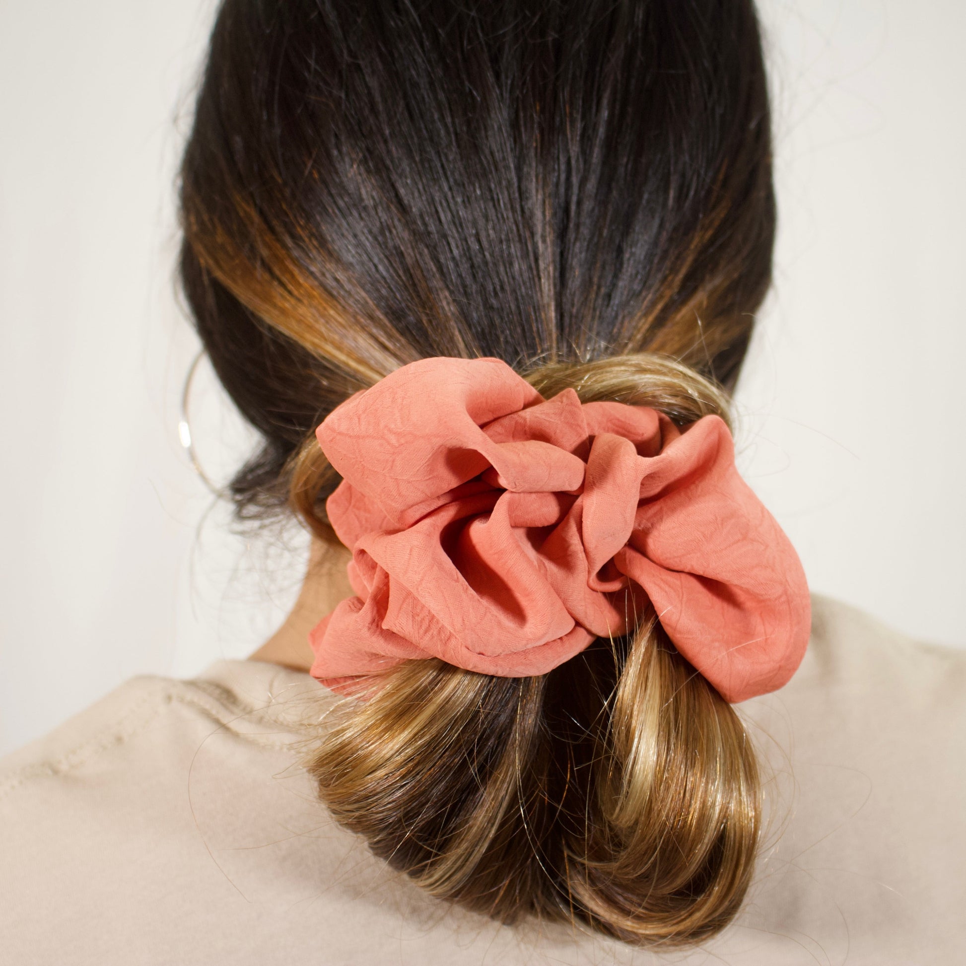 close up, of terracotta jumbo scrunchie on hair bun