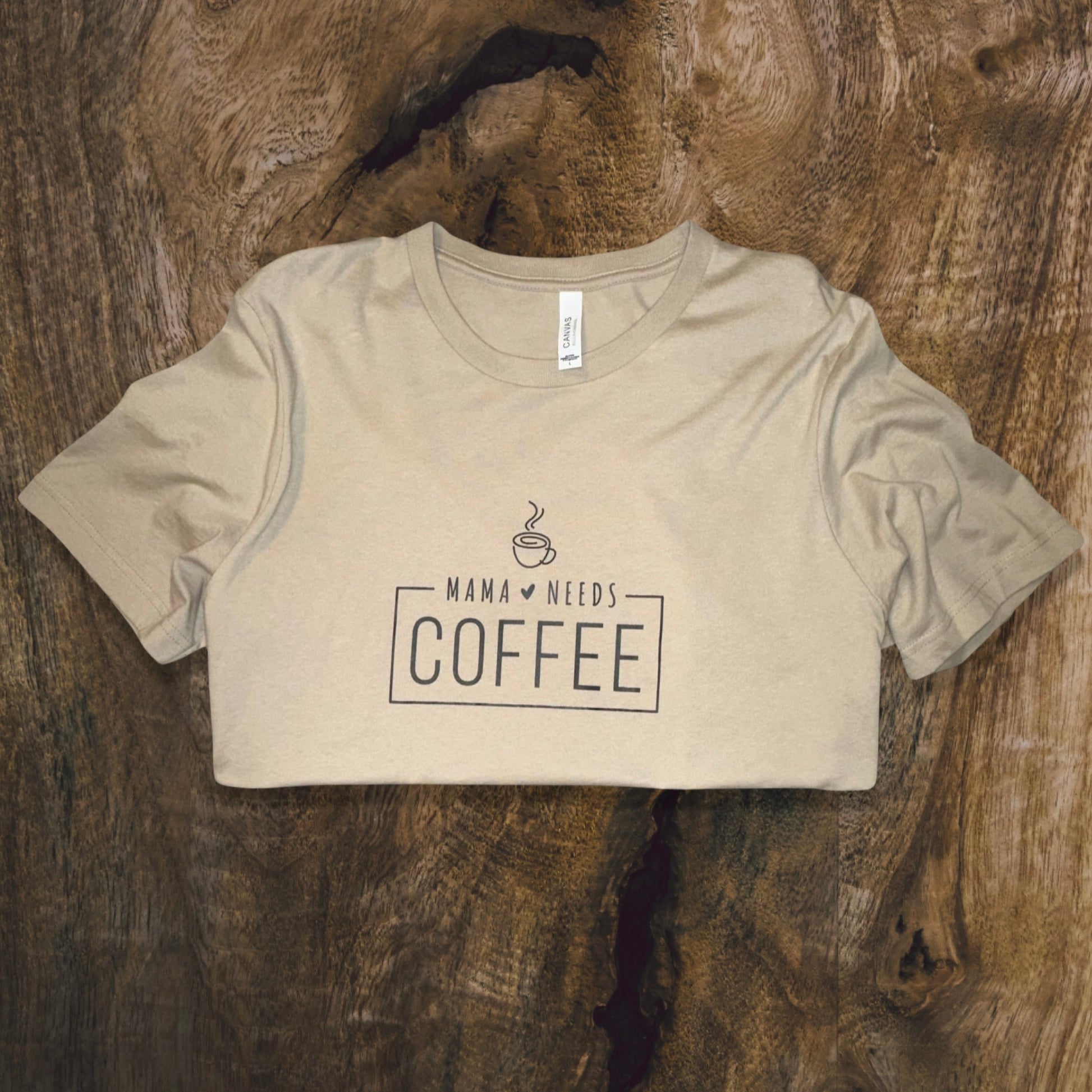 front side, close up of t-shirt in tan color with wording mama needs coffee