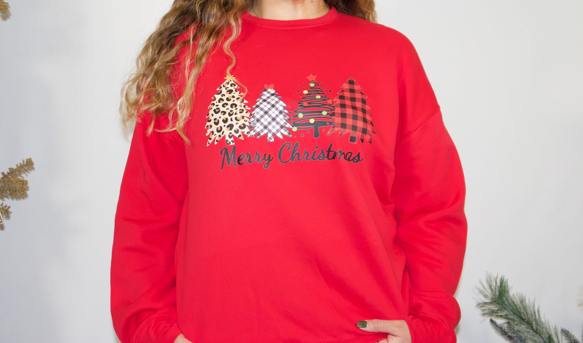 RED SWEATSHIRT WITH FOUR DIFFERENT PATTERN CHRISTMAS TREES AND BLACK LETTERS SAYING MERRY CHRISTMAS FRONT SIDE AND CLOSE UP